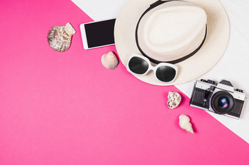 Woman's accessories lying flat on pink paper table background. Pastel colors with copy space around products . Image taken from above, top view. Minimal style with room for text