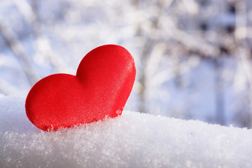 Valentine's Day. Red heart in the snow. Congratulatory background.