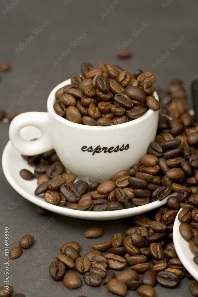 Poster still life of roast coffee beans and espresso cups on a tiled kitchen work surface