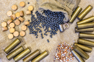 background on the old burlap lie brass metal shell casings with a shot