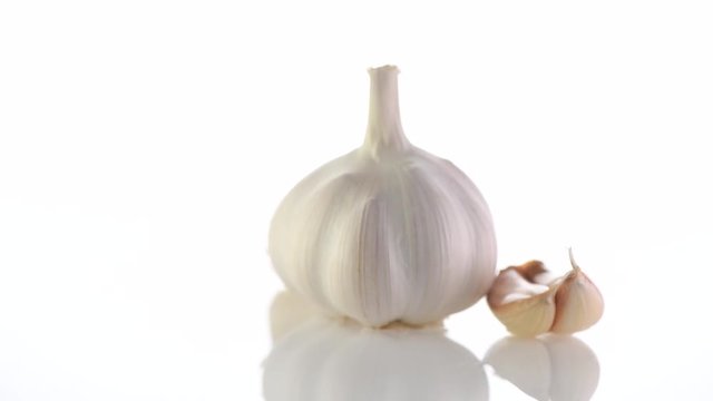 Garlic. Organic raw garlic bulb rotated on white background. 4K UHD video footage. 3840X2160