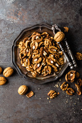 Walnut kernels and whole walnuts on rustic old wooden table