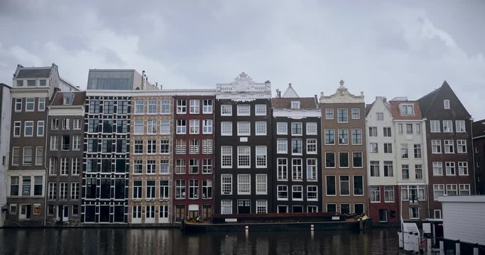 Archetypal apartments along a canal in Amsterdam. Cinematic 4K UHD footage / establishing shot.