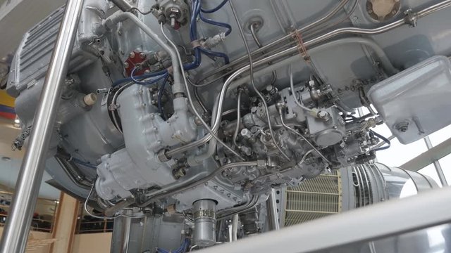 The structure of aircraft engine with lots of pipes, pumps, compressors, gears, pulleys, blades, valves, hydraulic and servo drives and other elements
