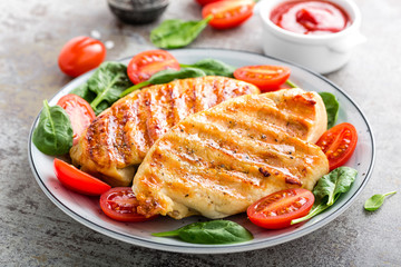 Chicken breast or fillet, poultry meat grilled and fresh vegetable salad of tomato and spinach. Healthy diet menu for lunch