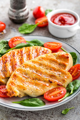 Chicken breast or fillet, poultry meat grilled and fresh vegetable salad of tomato and spinach. Healthy diet menu for lunch