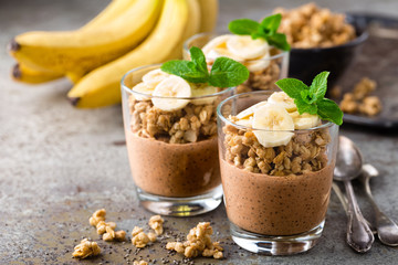 Layered chocolate chia pudding parfait with banana, granola and yogurt, dessert