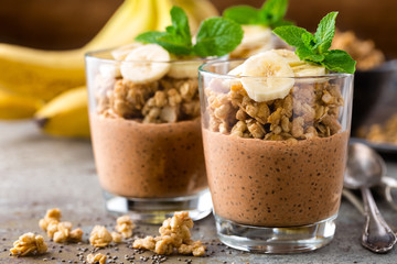 Layered chocolate chia pudding parfait with banana, granola and yogurt, dessert