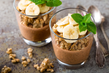 Layered chocolate chia pudding parfait with banana, granola and yogurt, dessert