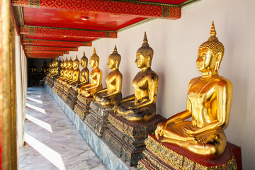  Row of golden buddha statues at Wat Pho temples in Bangkok , Thailand.