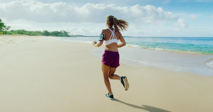 Athletic young woman running on the beach