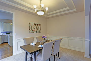 Chic dining room accented with wall panel mouldings and tray ceiling.