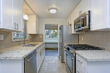 Photo of a small compact kitchen with white shaker cabinets