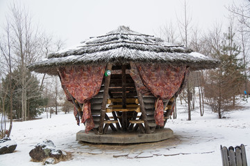 Wooden gazebo in the forest in winter day.