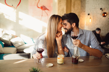 Cute romantic couple drinking red wine. Couple celebrating anniversary, Valentine's day. - Powered by Adobe
