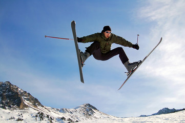 Jumping alpine skier in mountains - 191700610