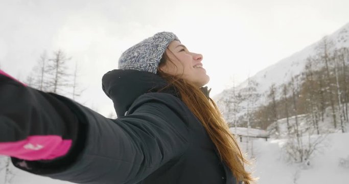 On a winter day, in the mountains a beautiful woman plays with the snow, breathes clean air immersed in nature. Concept of: winter holidays, family, christmas, mountain