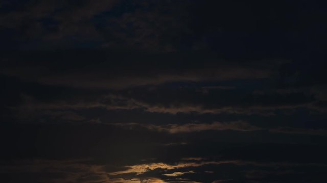 4K timelapse of moon moving between clouds
