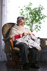 Close-up Portrait of Senior Woman Knitting with Wool, Grandmothers Hands Knit Wool Yarn. Craft is Hobby of Old Women. Senior Lady, Happy Granny Knitted Sweater Handmade. 