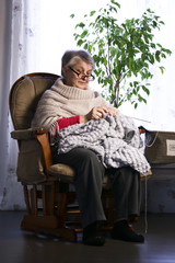 Close-up Portrait of Senior Woman Knitting with Wool, Grandmothers Hands Knit Wool Yarn. Craft is Hobby of Old Women. Senior Lady, Happy Granny Knitted Sweater Handmade. 