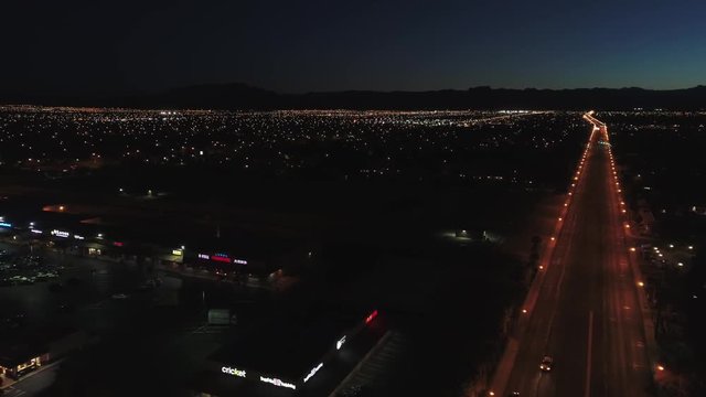 Aerial establishing shot of a large city with lights at night dolly