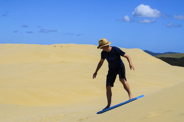 surfing on sand dunes at Cape Reinga, New Zealand