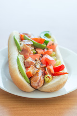 LA style hot dog on white plate.