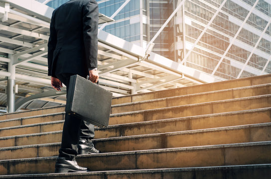 Young Handsome Business Man Holding Briefcase And Walking Up The Stairs Going To Work Time At Morning In The City, Determination, Confidence, Lifestyle, Rush Hour, Grow Up And Successful Concept