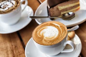 Naklejki  Kubek gorącej kawy Cappuccino na drewnianym stole w kawiarni at