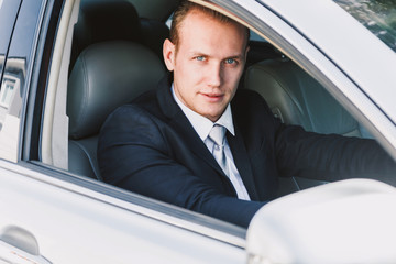 Handsome businessman in suit in a car