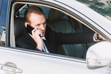 Businessman use smartphone while driving the car