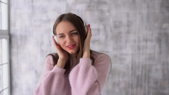 portrait of young girl having fun and listening ti the music with headphones. slow-motion