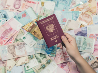 russian passport  on Asia money background . Currency of Hong Kong, Indonesia, Malaysia, China, Thai, Singapore dollar. Travel and business concept 