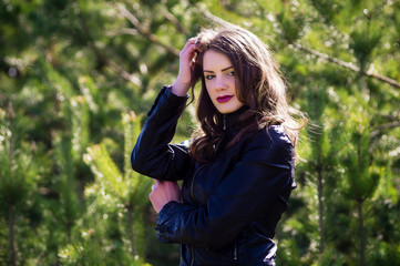 Young beautiful woman in the summer in the woods among the trees.