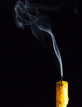 Yellow Candle and white smoke on black background