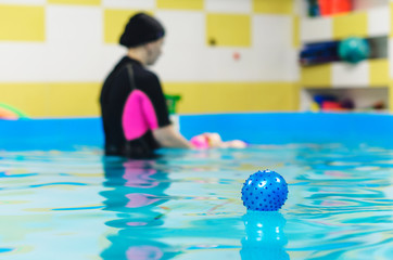 Blue rubber ball floating in the pool