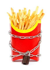 Ban on potatoes for diet and cholesterol reduction. The French fries in the packing box are wrapped around the chain and closed on a padlock. White isolated background