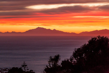 Fototapeta na wymiar Sunset behind ocean and mountain