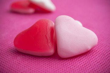 Obraz premium bonbons en forme de coeur sur fond rose