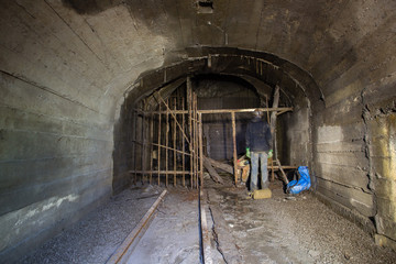 Underground abandoned gold ore mine shaft tunnel gallery with miner