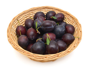 Sweet and ripe plums in basket on white