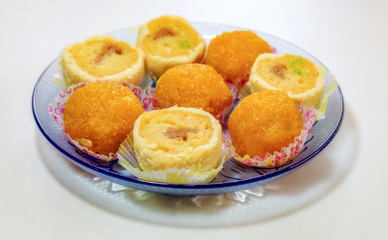 Bengali Indian sweet dessert displayed on a glass plate isolated on white background. Photograph shot in selective focus.