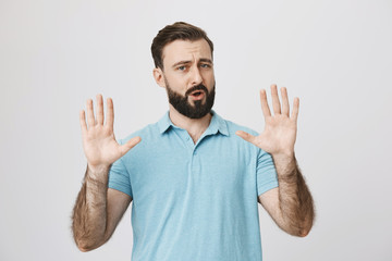 Fototapeta premium Portret atrakcyjny dojrzały mężczyzna pokazujący trzymanie gestu z podniesionymi dłońmi i otwartymi ustami, stojący na szarym tle. Wow, chwileczkę, wszystko stało się inaczej. Przesadzasz