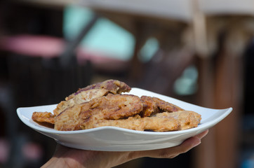 Fried banana in plate with woman hand ,seaside