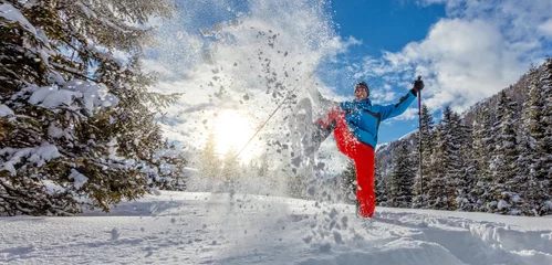 Keuken foto achterwand Wintersport Jonge man lopen op sneeuwschoenen in poedersneeuw.