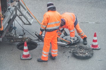 Straßenarbeiter bei Kanalarbeiten