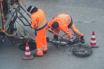 Straßenarbeiter bei Kanalarbeiten
