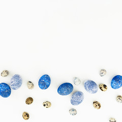 Stylish Easter frame background with quail and blue eggs with copy space for text on white background. Flat lay, Top view