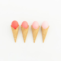 Pink Easter eggs in waffle cones isolated on white background. Flat lay. Top view. Creative Easter concept.