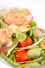 Baby spinach, dry sausage, matured cheese, roast tomatoes, thyme-balsamic vinaigrette salad on a white background